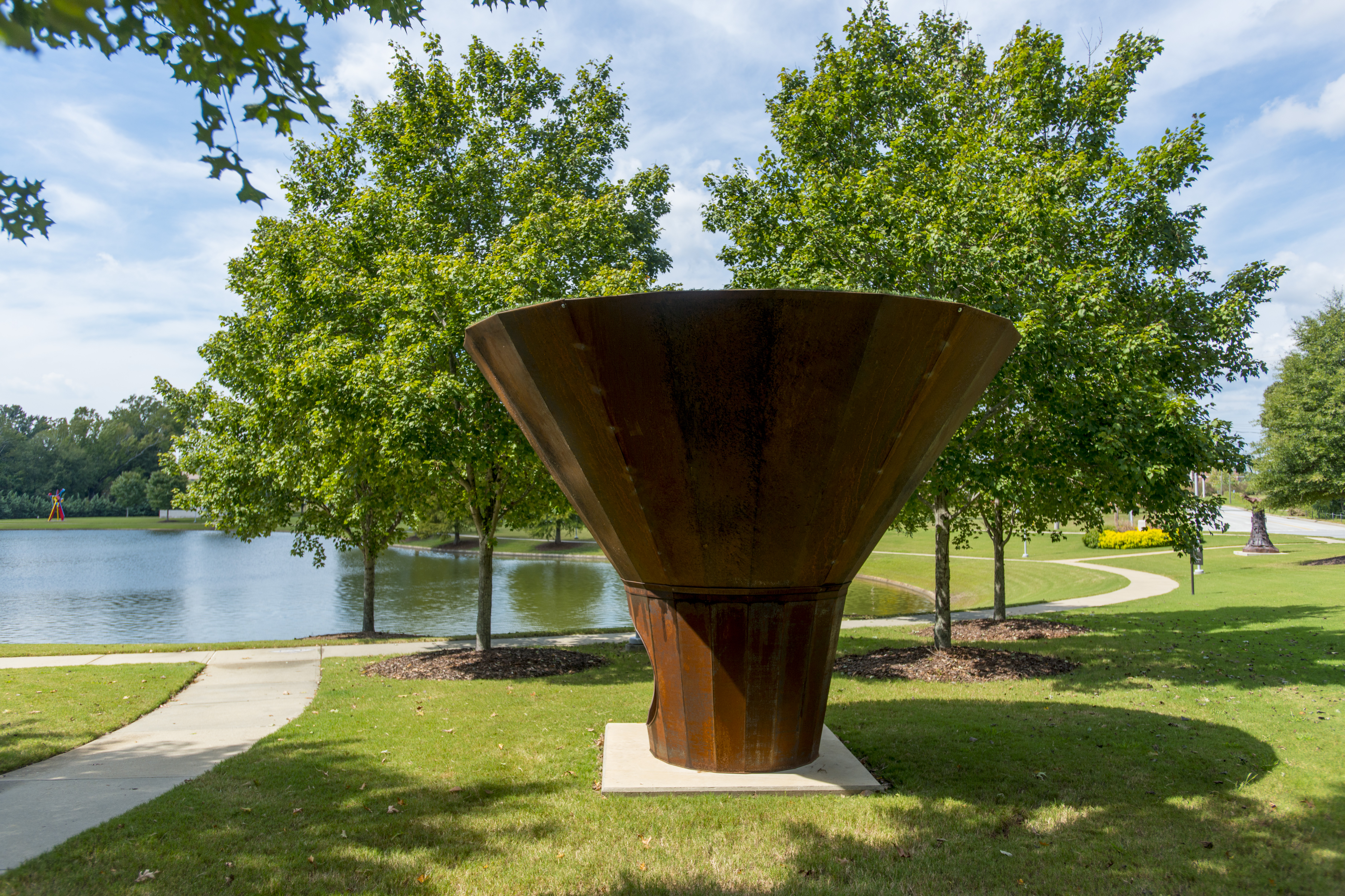 A steel scuplture in the shape of a cone, with a small opening at the base