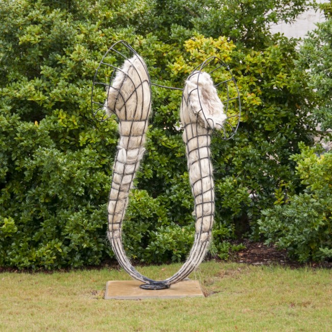 Horseshoe-shaped sculpture made from artificial human hair and steel