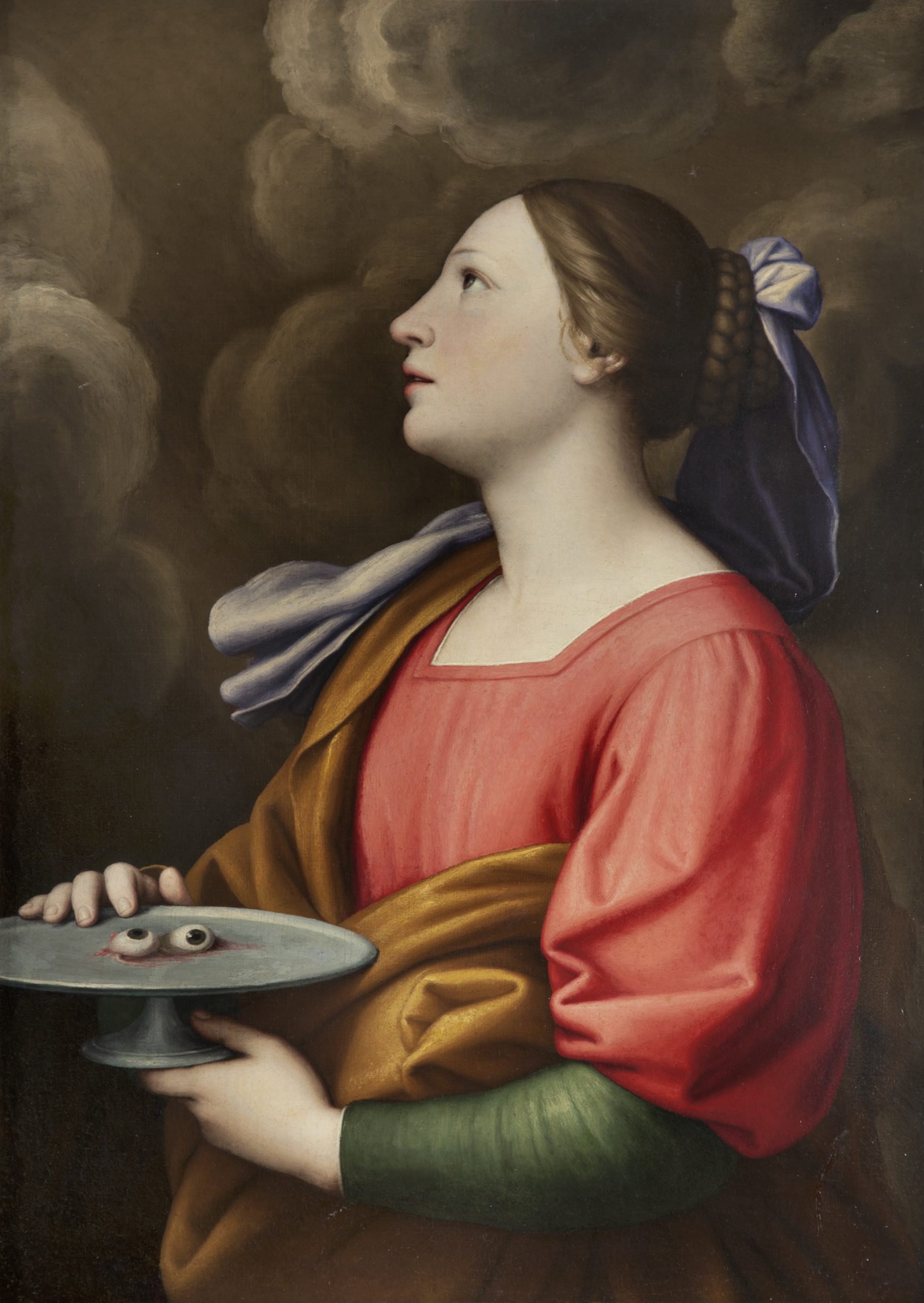 A woman looks towards heaven, holding a plate of eyeballs.