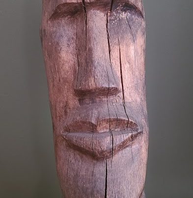 A wooden carving of a head.