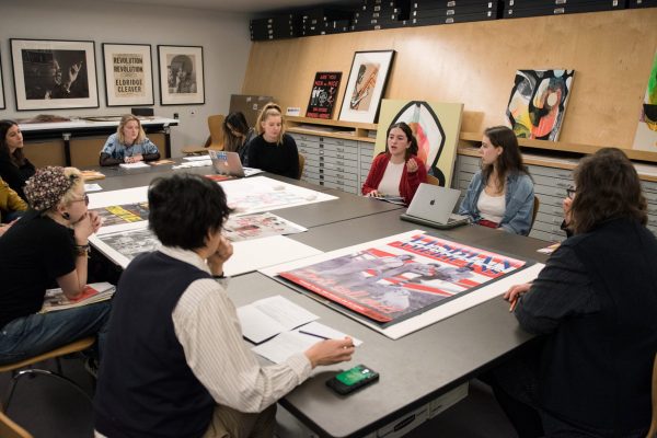 Students sitting at a table with posters laid out