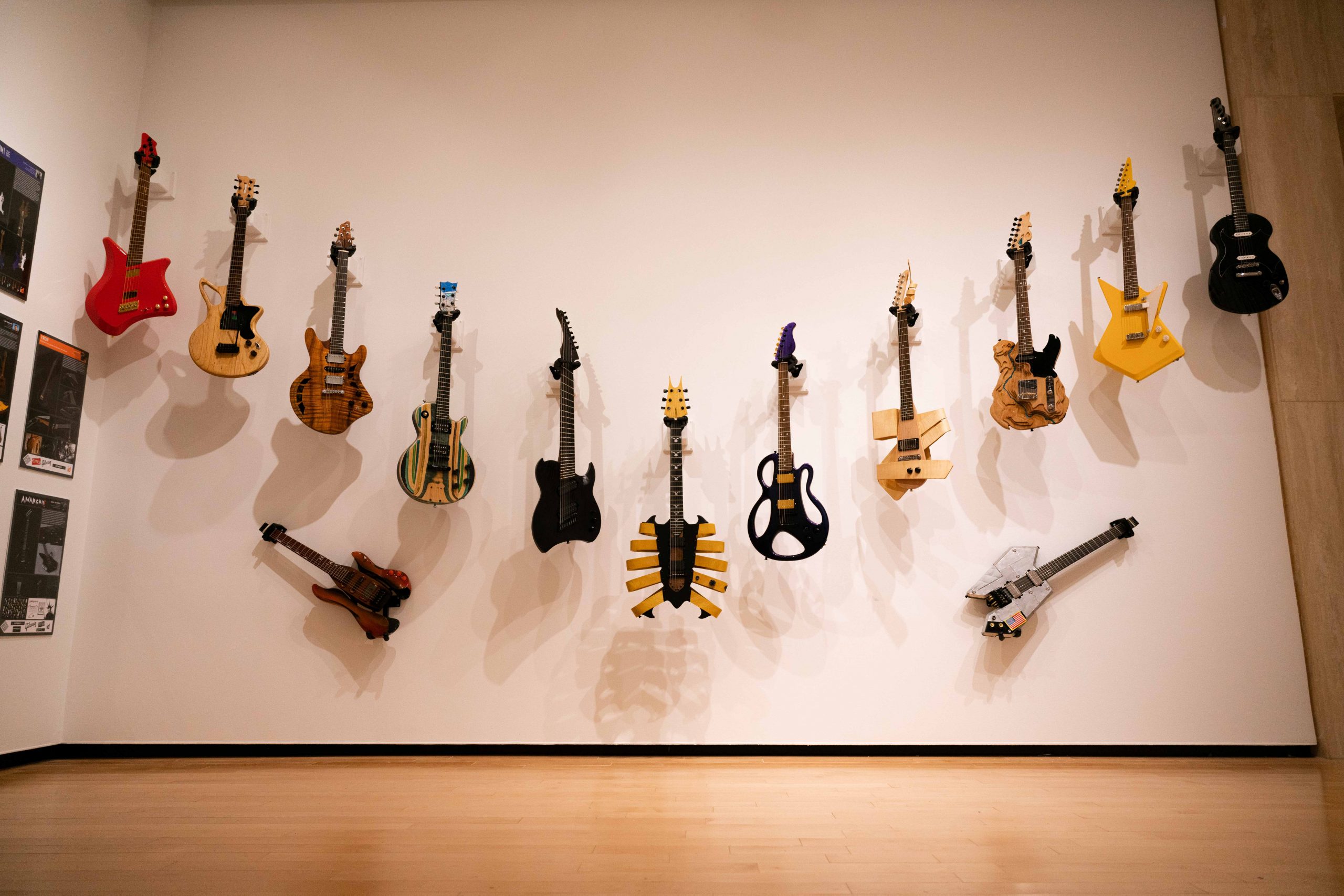 Uniquely decorated electric guitars arranged in a V pattern on a wall