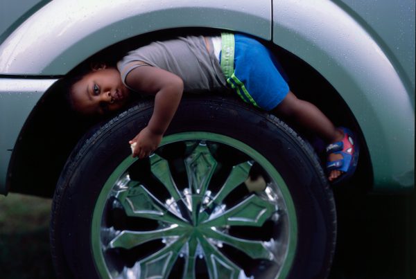 A small boy rests on a tire