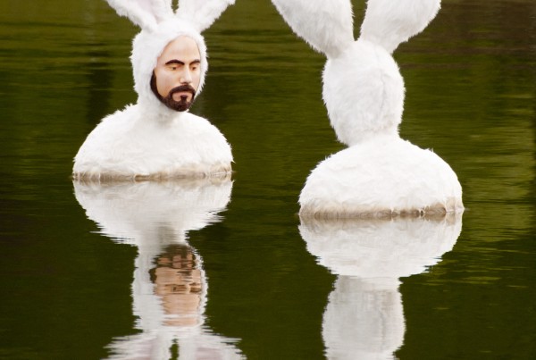 A water feature sculpture of two men in bunny suits