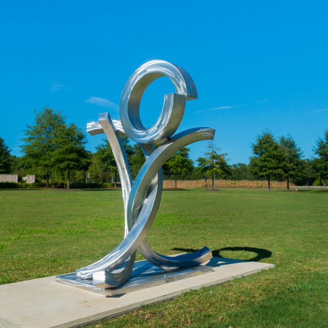 An outdoor steel sculpture with lines, curves and geometric shapes