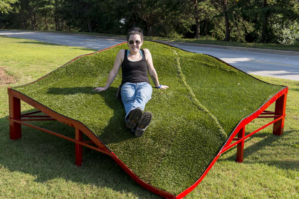 Stacey Rathert of Mississippi poses with her work You Are Here, 2013 Steel, artificial turf, and ground cover