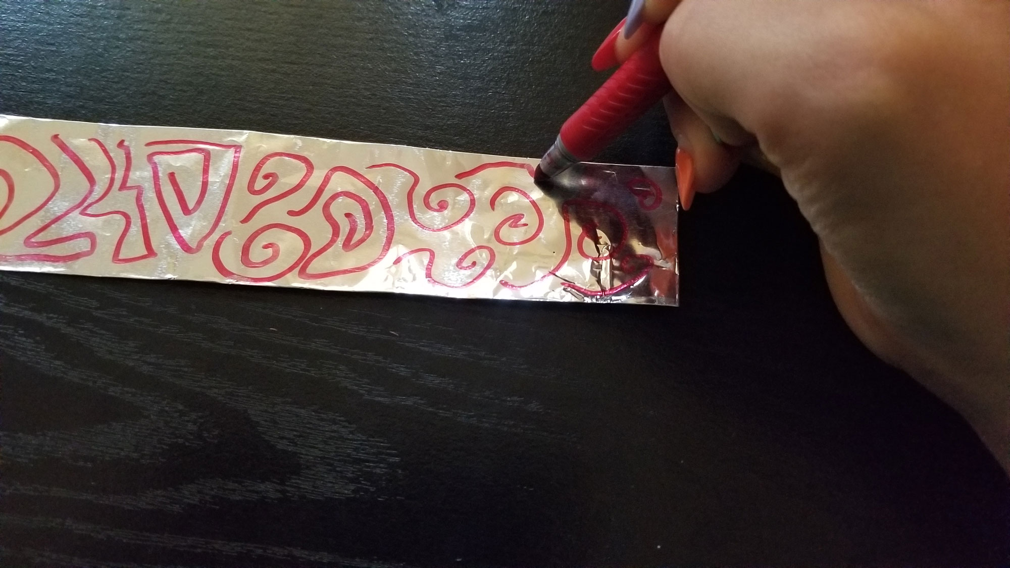 Draw a variety of abstract shapes on aluminum foil to create a pattern.