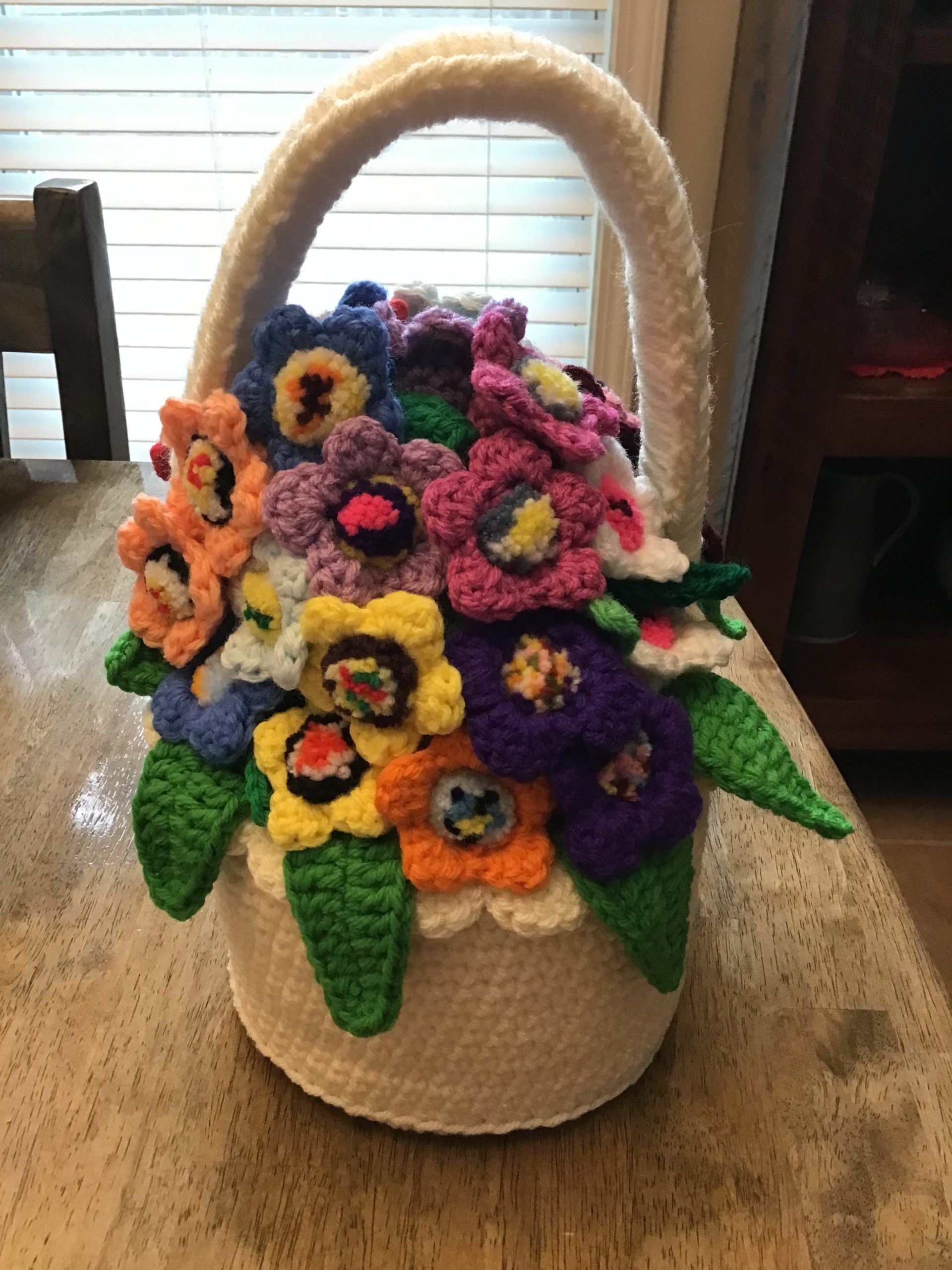 A basket and flowers made from yarn.