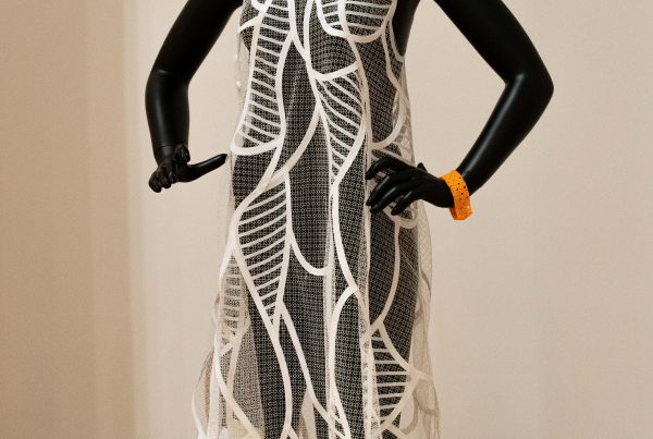 A dress hangs on a mannequin that is made of 3D printed materials.