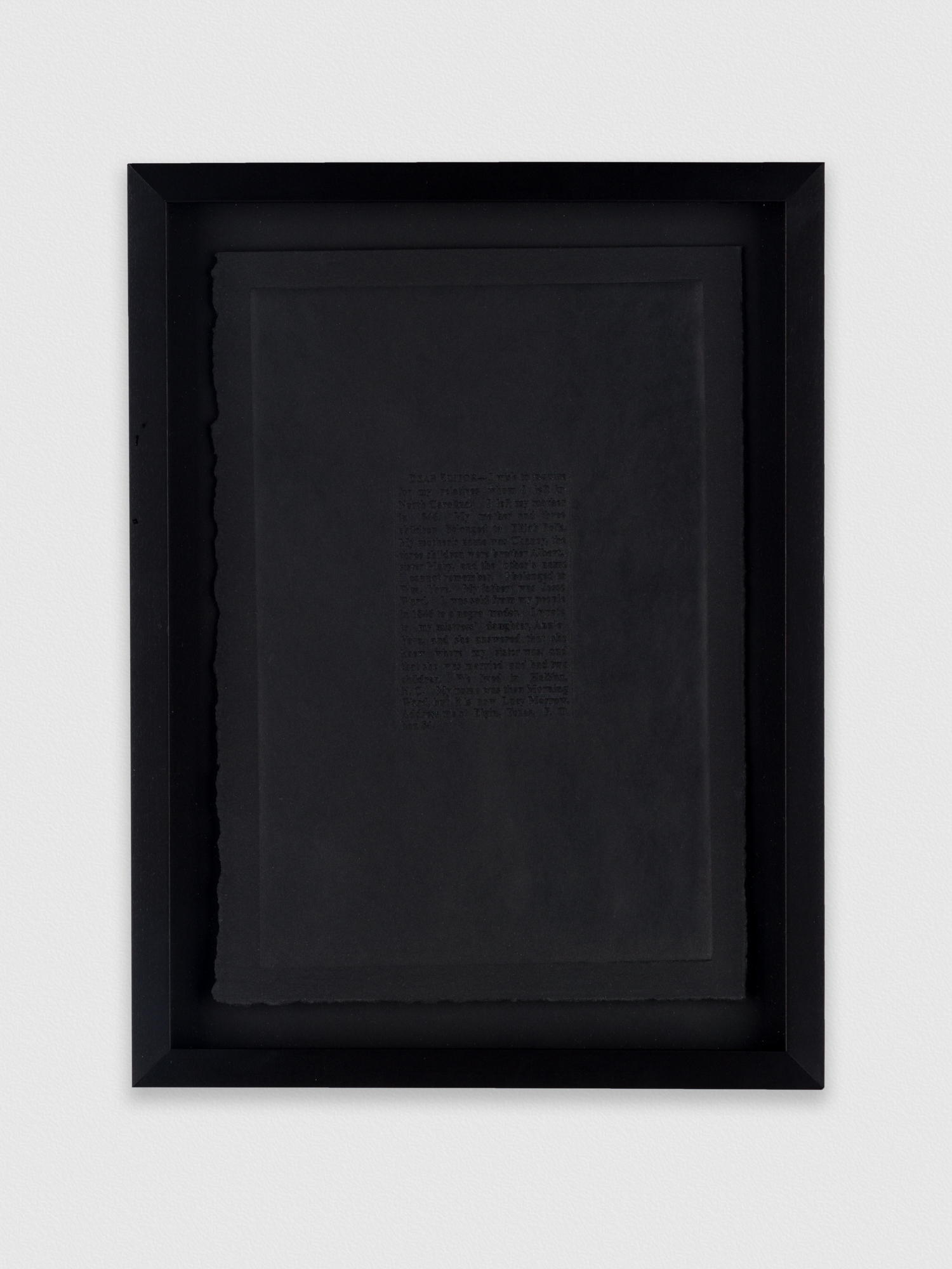 A framed piece of typed text that is almost completely redacted by a black rectangle