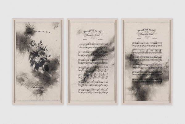 Three pieces of framed sheet music with large, dusty smudges of graphite and charcoal.