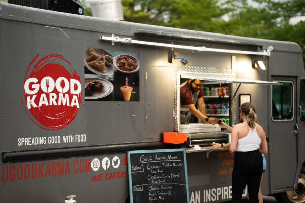 A person buying dinner from a food truck.