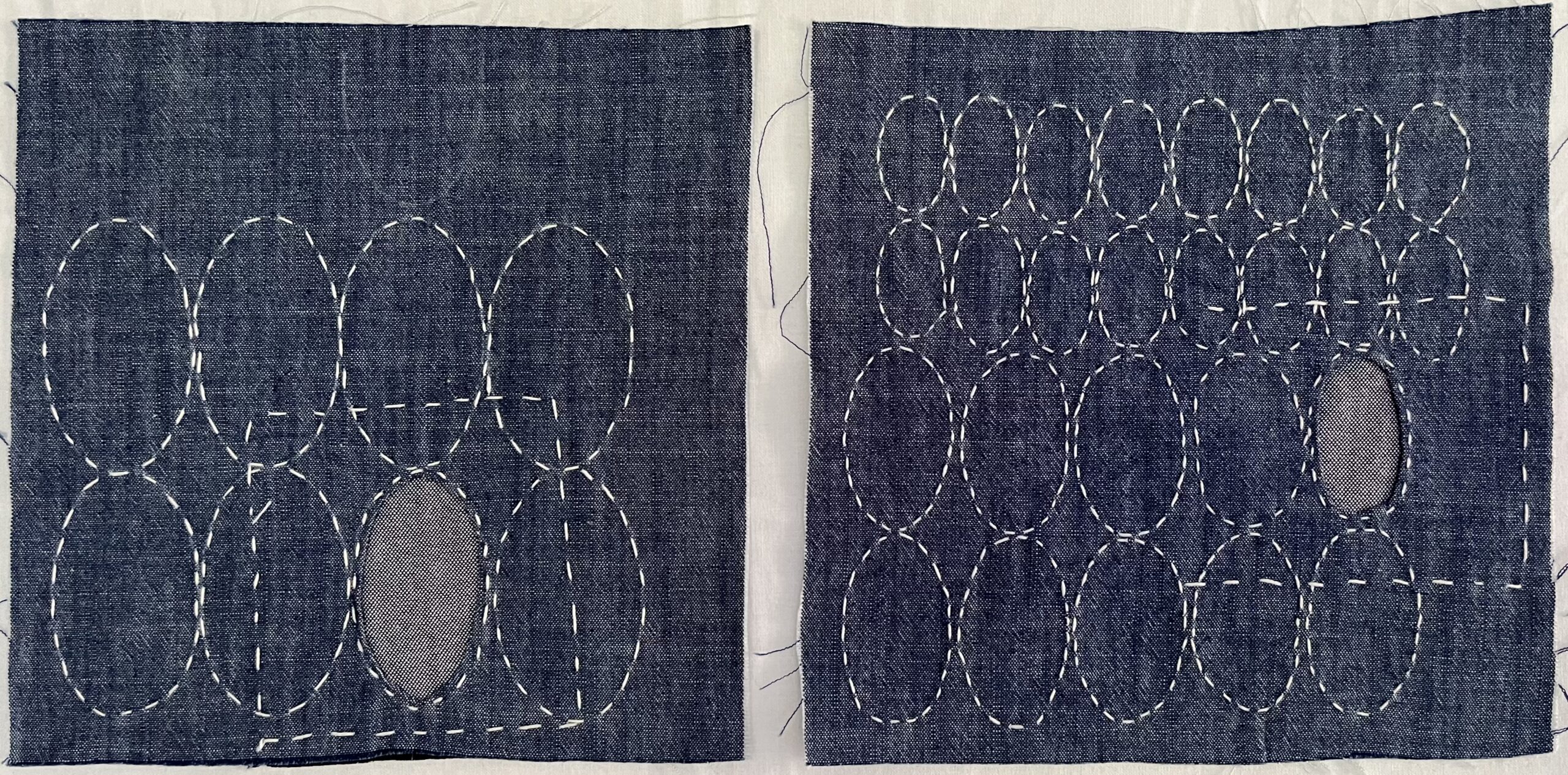 Squares of denim with patterned stitches in the fabric demonstrating the mending practice to take place.