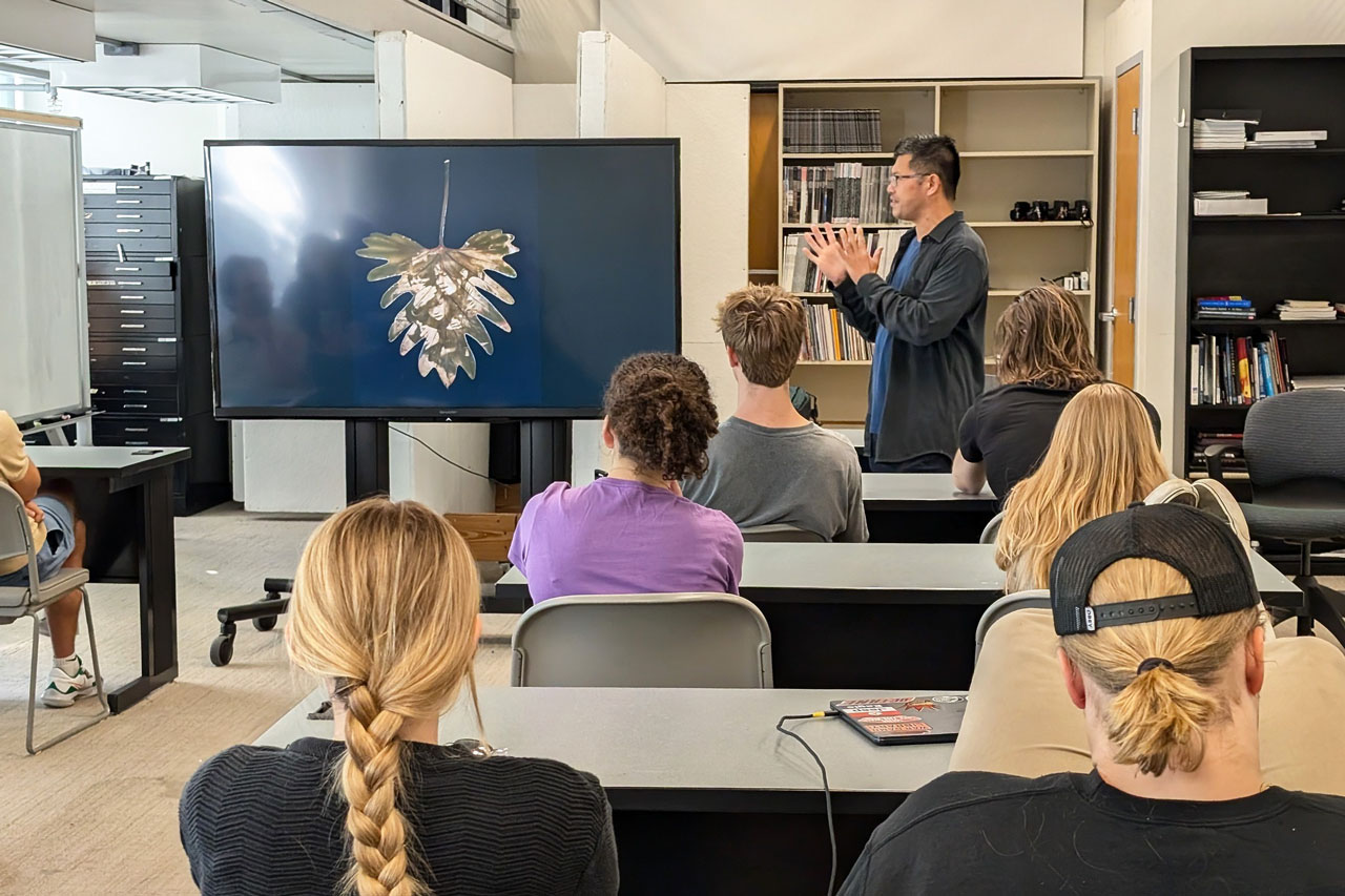 A person speaks to a class of college students