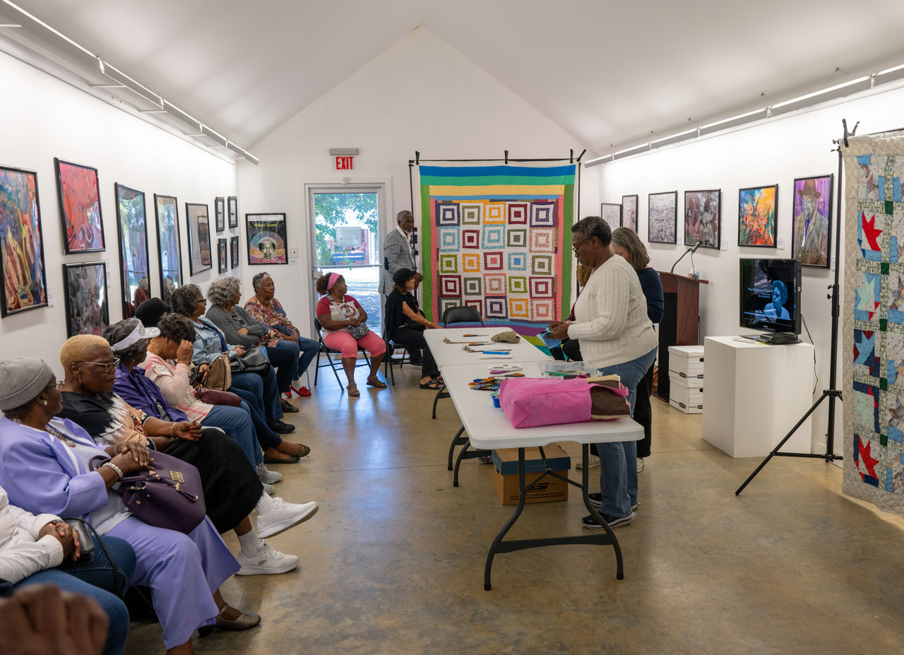 Community members select fabric for a quilting bee.