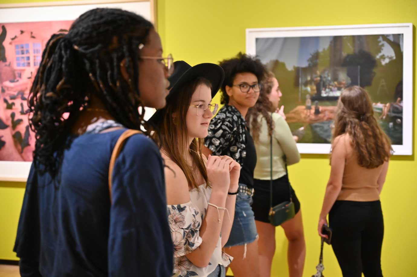 College students look at objects in a gallery.