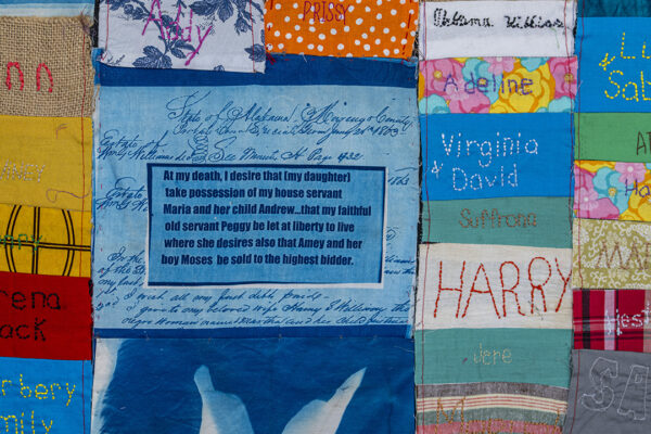 Close up shot of a quilt showing squares of fabric with names.