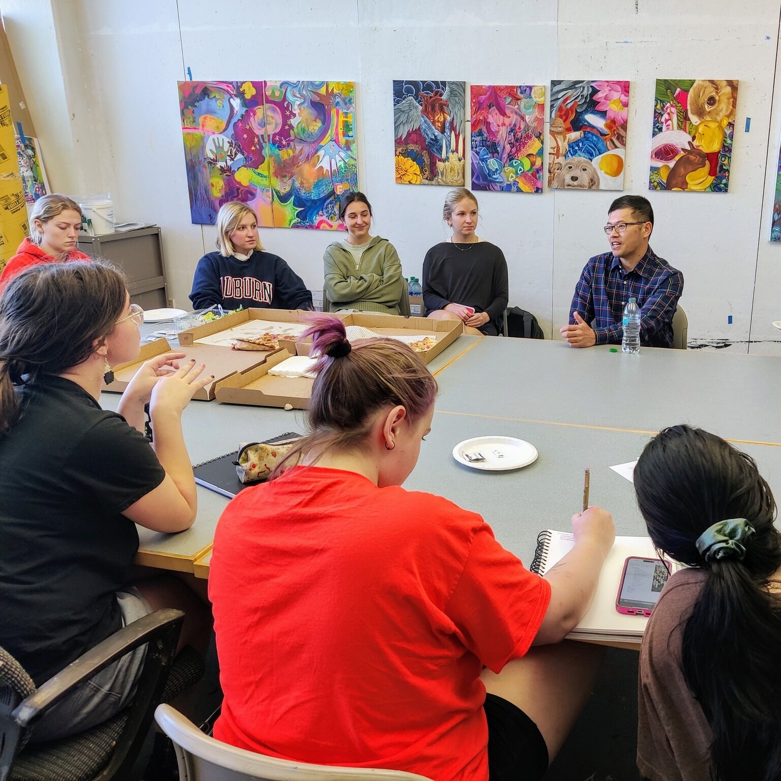 Artist Binh Danh addresses students seated around a table.