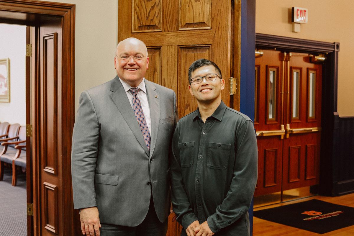 Two people stand side-by-side for a portrait.