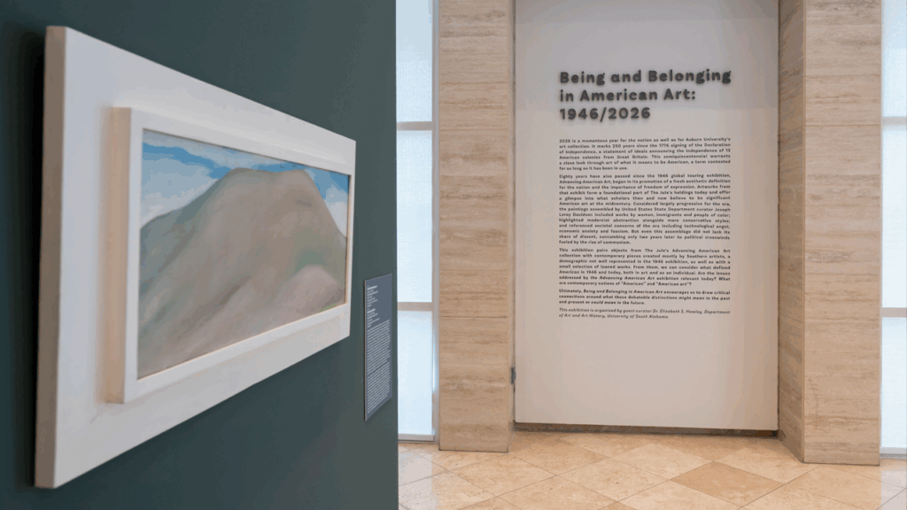 Installation view of painting and wall text in a gallery.