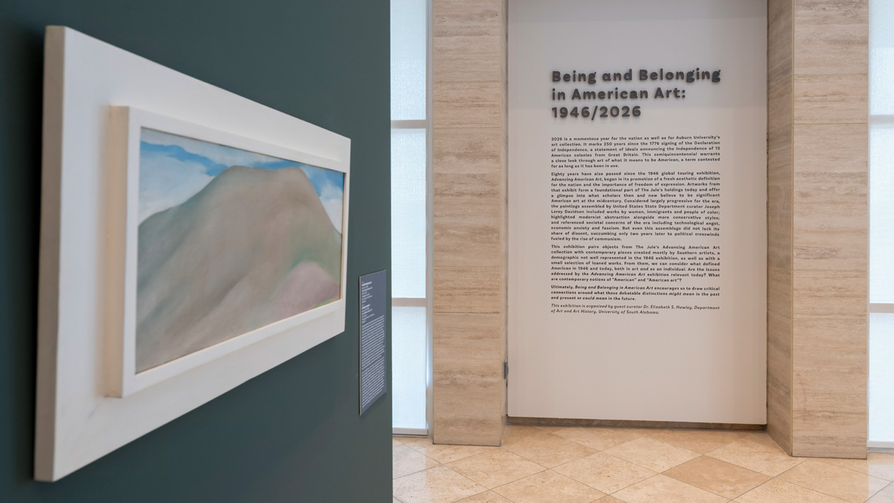 Installation view of painting and wall text in a gallery.