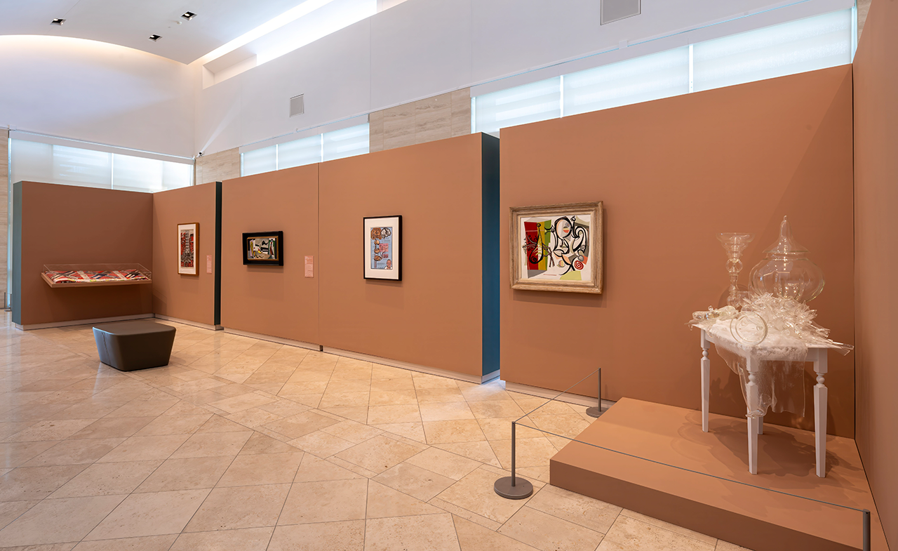 Installation view of paintings and three-dimensional objects in a gallery.