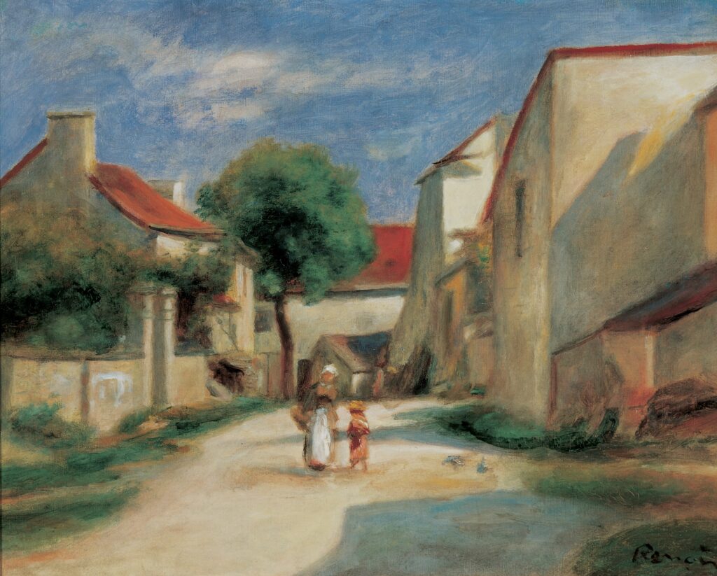 A woman and child walk down the street of a village comprised of cream-colored buildings with red rooftops. Greenery and trees line the street and the scene is lit by sunlight and set against a bright blue sky with wispy clouds.