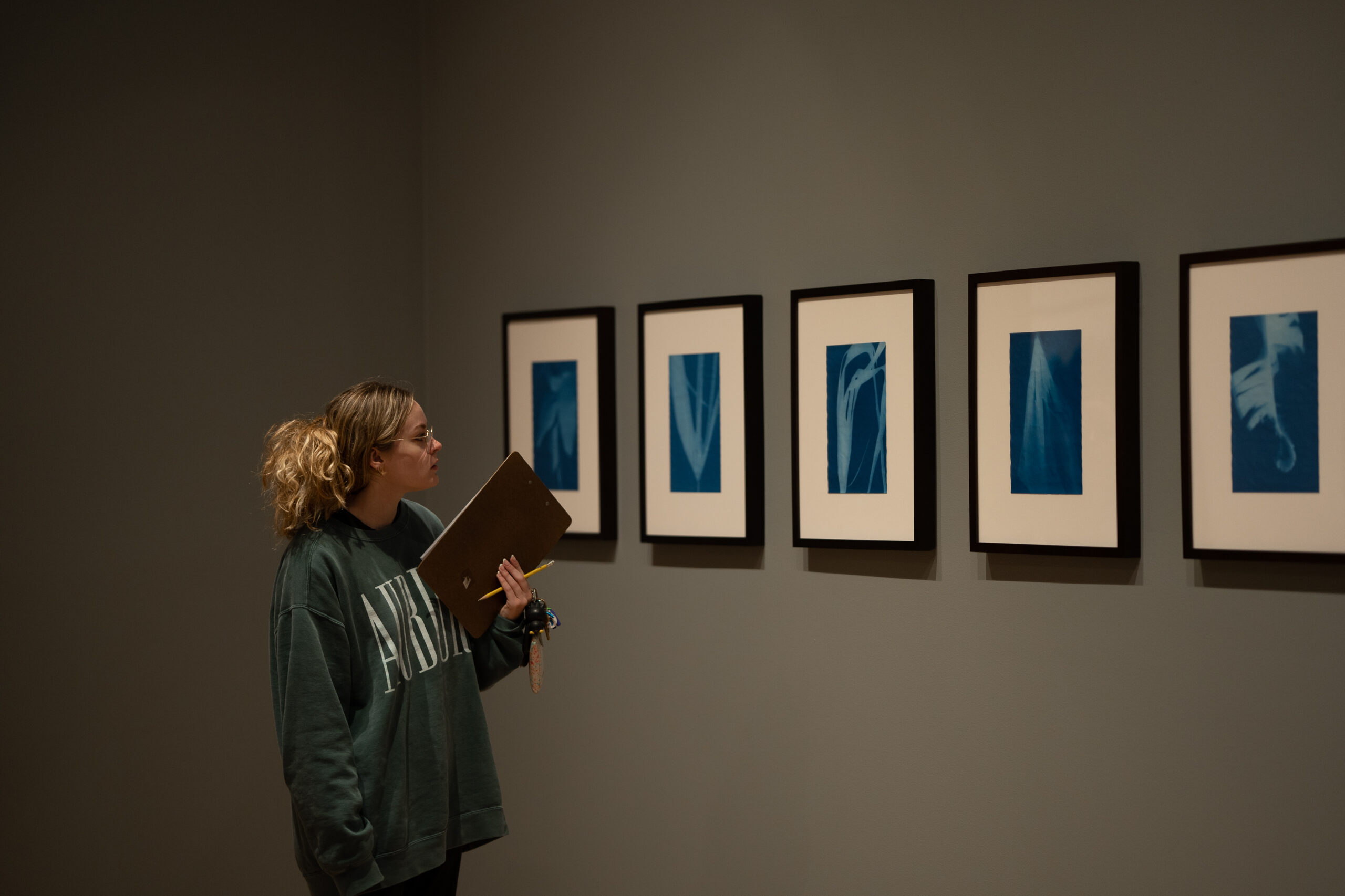 2022_11-17 Manon with Class-12 A student looks at a grouping of 2D objects displayed on a gallery wall