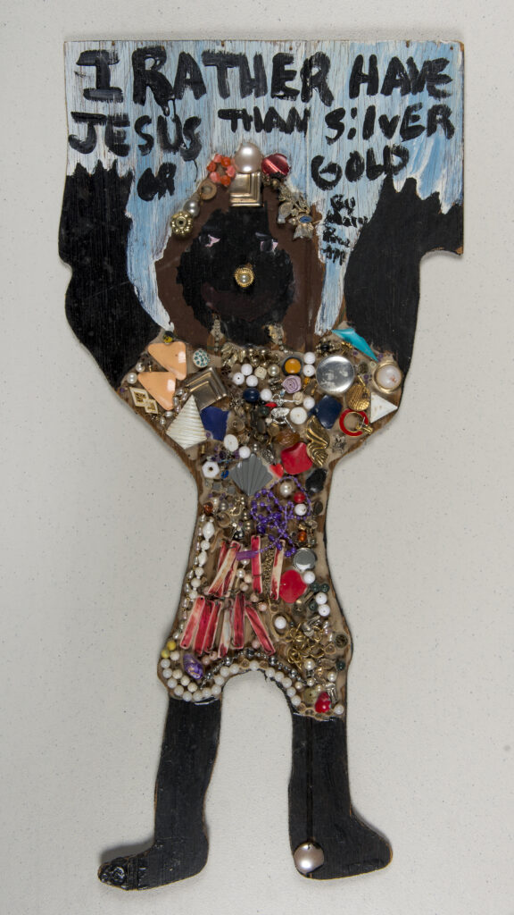 An image of an artwork depicting a person in colorful clothing holding arms up to a sky with black lettering spelling "I rather have Jesus than silver or gold."