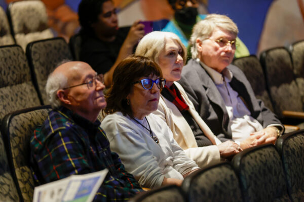 Audience members seated in auditorium chairs listening at the Auburn Forum.